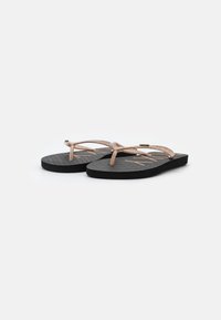 Must have ansad mustade ja roosakuldsete metallist rihmadega mustad plätud, millel on tekstuuriga talla ja ristikkattega disain. Minimalistlik ja juhuslik stiil.