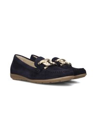 Marineblauwe suede instappers met een gevlochten gouden kettingaccent en een rubberen zool. Gladde textuur met stikseldetails langs de randen.