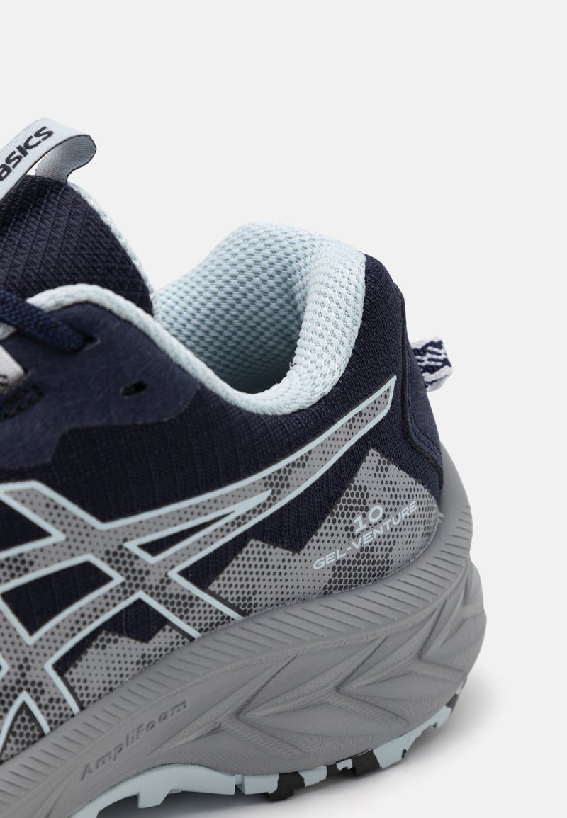 Chaussure de sport marine et bleu clair avec une tige en mesh, semelle en caoutchouc et logo Asics bien en vue ; dotée de motifs texturés et d'un design soutenant.