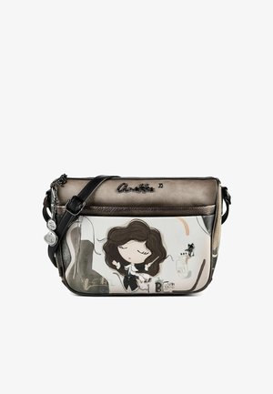 Crossbody-Tasche mit metallisch braunem Oberteil, Cartoon-Mädchen mit wehenden Haaren auf der Vorderseite, schwarzem verstellbarem Riemen und kleinen Anhängern in Form von Musiknoten.