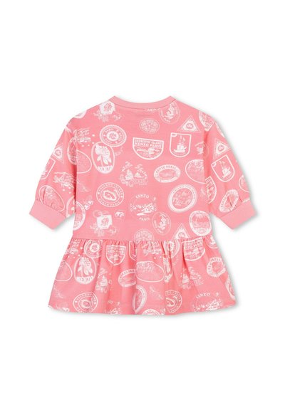 Robe longue à manches longues rose avec une jupe froncée, ornée d'imprimés graphiques blancs de badges et de logos sur tout le tissu. En coton doux.