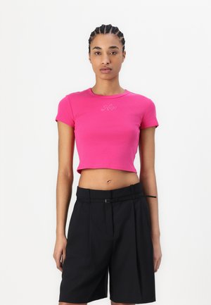 Rosa verkürztes T-Shirt aus weicher Baumwolle mit rundem Halsausschnitt und kurzen Ärmeln. Kombiniert mit hoch taillierten schwarzen Shorts mit einem Gürteldetail.