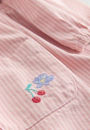 Różowa tkanina w paski z haftowanym kwiatem w odcieniach niebieskiego i zielonego, w towarzystwie czerwonych wiśni. Posiada kieszeń z widocznym ściegiem.