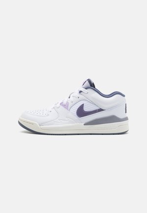 Baskets basses Nike blanches et grises avec un swoosh violet, des lacets blancs et un bout perforé sur un fond clair uni.