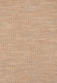 Prążkowana dzianina w ciepłym odcieniu beżu, z delikatną teksturą i subtelnymi wariacjami w kolorze oraz wzorze.