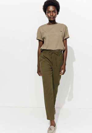 T-shirt à manches courtes kaki avec un logo sur la poitrine, associé à un pantalon à taille élastique vert olive doté d'un cordon de serrage et de poches latérales.