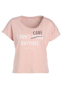 Světle růžová košile s krátkým rukávem s nápisem "UŽ MI NEZÁLEŽÍ ~NA SVAČENÍ~" a pod tím "JEN HRÁT" bílými a černými písmeny.