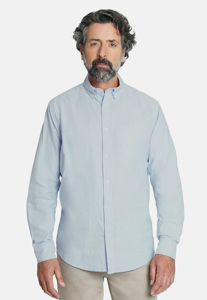 Camisa de botones de manga larga azul claro con cuello. Textura suave y corte regular, con un dobladillo recto y un bolsillo en el pecho.