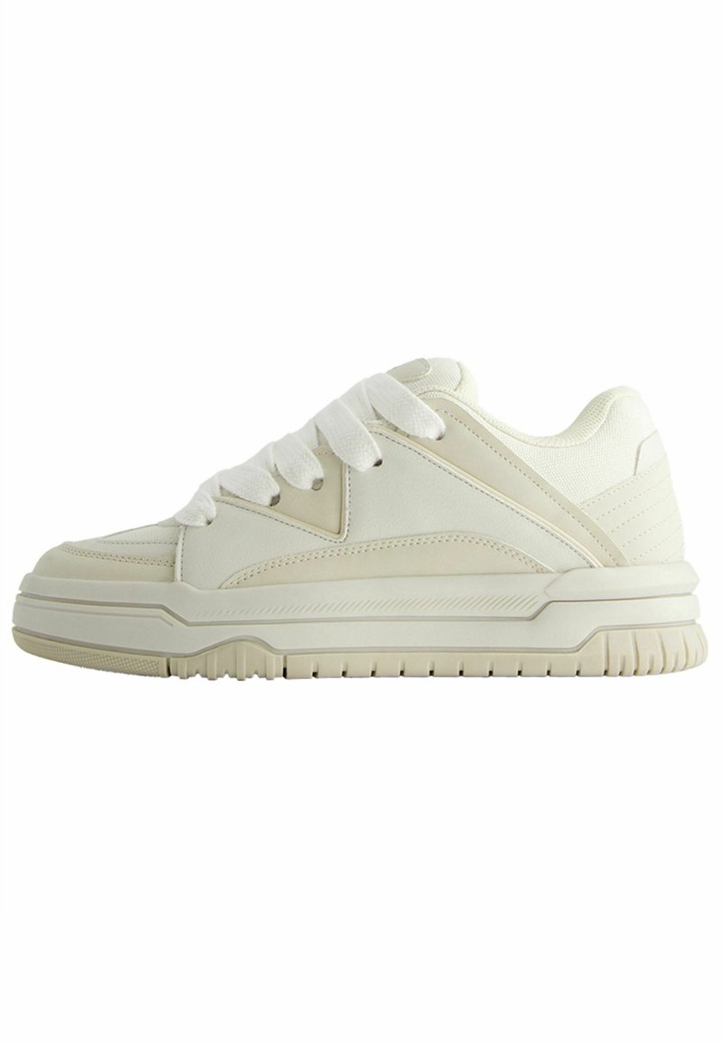 Baskets basses off-white avec semelle épaisse, col rembourré, panneaux en tissu et cuir, et larges lacets blancs sur fond blanc.