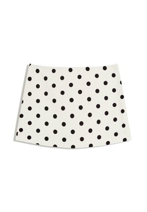 Witte minirok met gelijkmatig verdeelde zwarte polka dots, rechte zoom en A-lijn silhouet tegen een effen witte achtergrond.