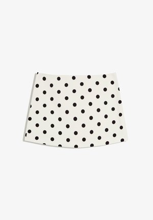 Hvid mininederdel med jævnt fordelte sorte polkaprikker, fladt skørt og A-formet silhuet på en ensfarvet hvid baggrund.