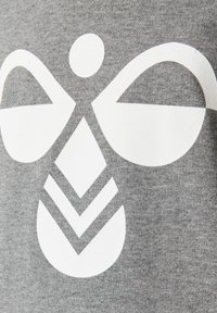 Grijze stof met een groot wit grafisch ontwerp met abstracte vormen, waaronder een cirkelvormig element en chevronpatronen.
