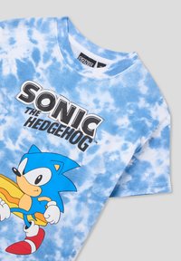 T-shirt tie-dye azzurro con un graphic di Sonic the Hedgehog e testo in grassetto che dice “SONIC THE HEDGEHOG.” Tessuto di cotone, maniche corte.