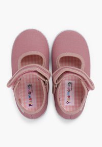Zapatos tipo Mary Jane de lona rosa con una correa de velcro, forro de tela a cuadros y suela de goma texturizada. Presentan una puntera redonda y cortes laterales.