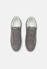 Sivi nubuk tenisice s okruglim vrhom, sa teksturiranim bočnim panelima, srebrnim detaljima i vezicama. Logo na jeziku; bijeli gumeni potplat.