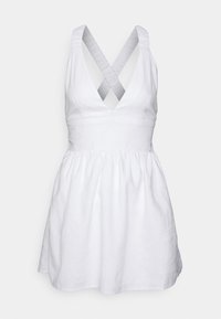 Bílé lněné šaty s přiléhavým korzetem, hlubokým V-výstřihem a křížovými ramínky na zádech. Rozšířená sukně se nařaseným pasem, hladká textura.