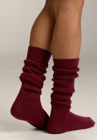 Bordeauxrode geribbelde sokken met een nonchalant ontwerp, voorzien van zachte, gestructureerde stof en halflange hoogte, die een comfortabele bedekking biedt.