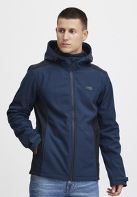 Jūras spēku mīksta pārvalka jaka ar melniem akcentiem, ar rāvējslēdzēju priekšā, regulējamu kapuci, sānu kabatām un šauru piegriezumu. Uz krūšu ir logotipa uzšuvums.