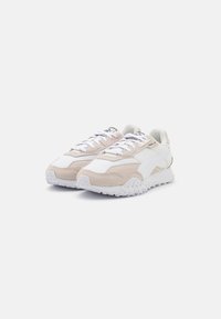 Sneaker realizzati in pelle e suede bianchi e beige, caratterizzati da una suola spessa con dettagli testurizzati e cuciture a contrasto.