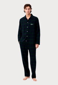 Ανδρικές πιτζάμες καρό σε σκούρο πράσινο και ναυτικό μπλε, με πουκάμισο με κουμπιά και παντελόνι με κεντημένο λογότυπο. Μαλακή υφή υφάσματος.