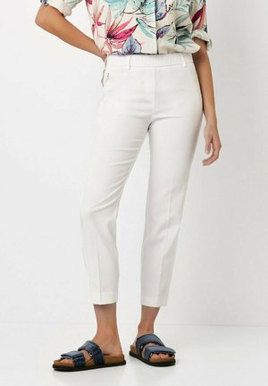White tailored trousers with a smooth texture, featuring a slim fit and cropped length. Paired with dark blue slide sandals, accented with straps.