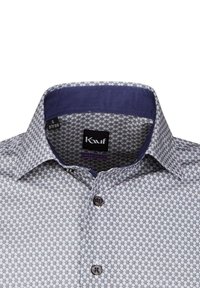 Camicia abbottonata con un motivo geometrico in blu navy e bianco, con un colletto a contrasto blu navy e bottoni marroni. L'etichetta della taglia mostra S 37/38.