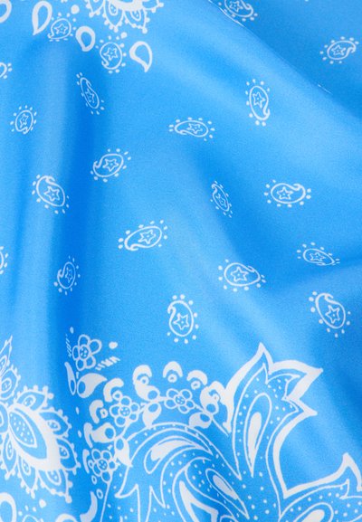 Μπλε ύφασμα με λευκά σχέδια πεϊσλεϊ και λουλουδιών, δείχνοντας πτυχώσεις και ομαλή υφή.