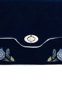 Marinblå sammetclutch med silverdetaljer; prydd med broderade blå blommor och gröna blad; rundad klaff och vit sömdekoration.