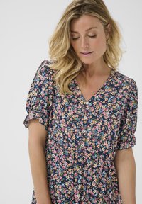 Rochie florală cu un fond navy, având un model colorat de flori, mâneci scurte tip bufant și decolteu în V cu nasturi.