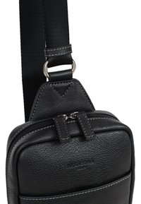 Borsa in pelle nera con superficie texture, compartimenti con zip e tracolla in nylon con anello di regolazione metallico.