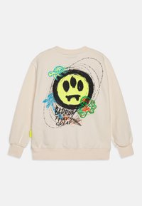 Sudadera crema con un gran gráfico de cara sonriente negra y amarilla, tortugas y un pulpo; presenta detalles coloridos y mangas ajustadas.