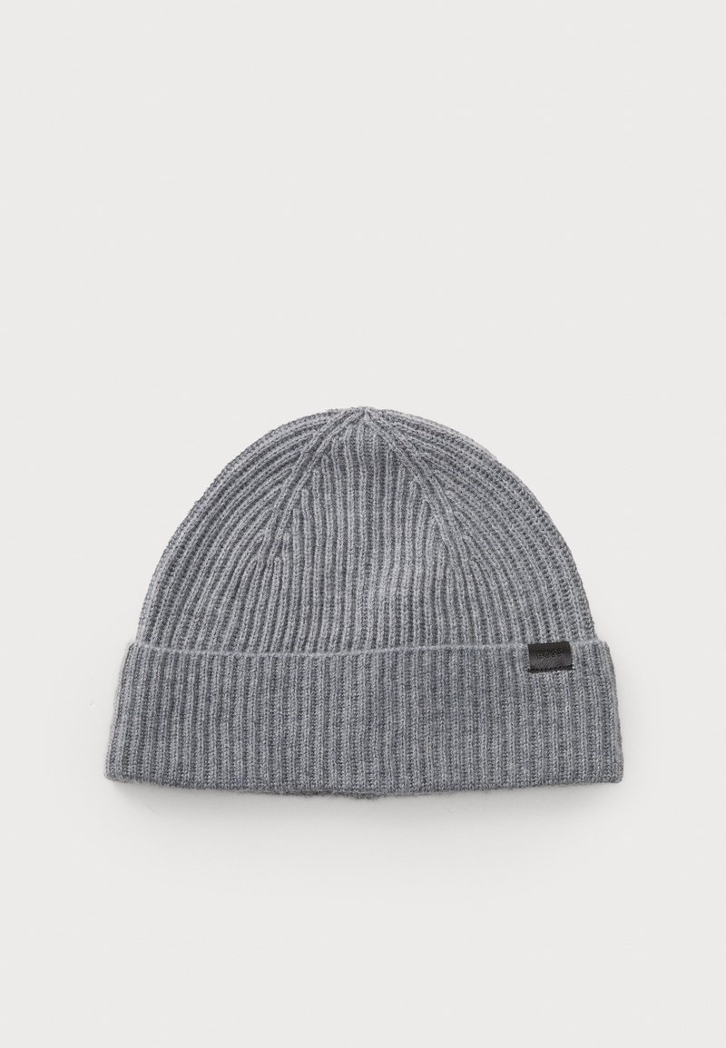 Gray knitted beanie with ribbed texture, featuring a folded cuff and a small black logo tag on the side. Classic round shape.