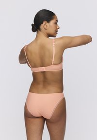 Peach-colored bikini set featuring a simple design, adjustable straps, and a back hook closure. Smooth texture with minimal detailing.