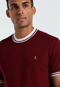 Bordeaux katoenen t-shirt met een witgestreepte kraag, voorzien van een klein pinguïnlogo op de borst, korte mouwen, slank ontwerp.