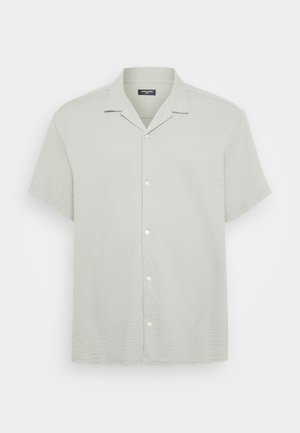 Kortermet, skjortebluse i lysegrått med et teksturert mønster. Har notched krage og hvite knapper foran.