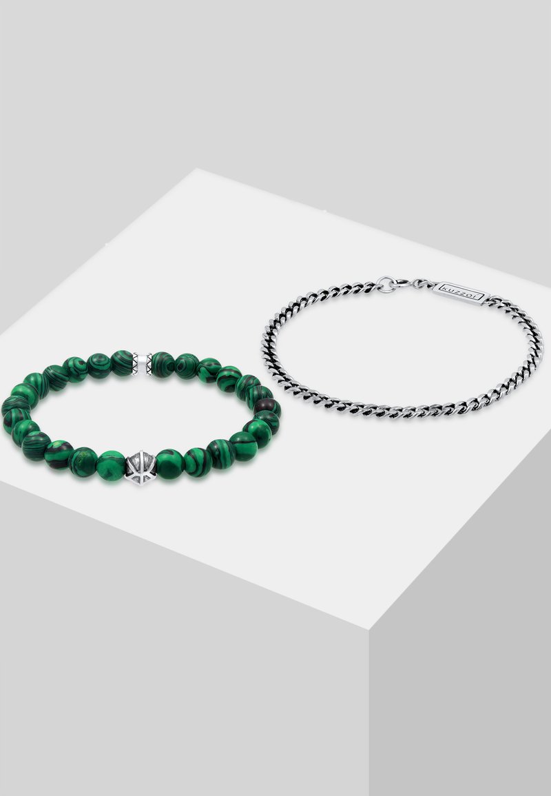 Grön malakitpärlarmband med silverackcenter bredvid ett silvrigt vridet kedjearmband, som visar upp olika texturer och former.