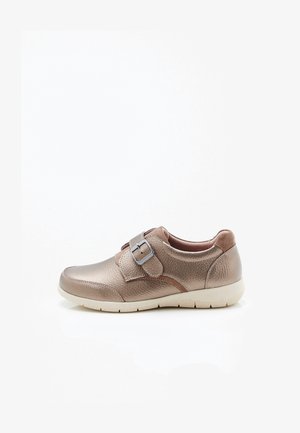 Chaussure décontractée pour femme en cuir bronze avec une large bride et une boucle en métal, col rembourré et semelle blanche flexible.