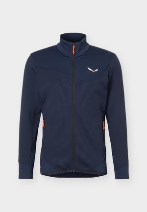 Marineblauwe, getextureerde jas met volledige ritssluiting, hoge kraag, oranje ritstrekkers op de zakken en wit logo op de linkerborst.