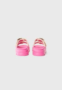 Rosa sandaler med tykk såle, med et flettet stroppdesign og detaljer i gull. Materialet ser slitesterkt og teksturert ut.