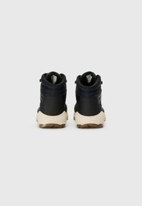 Høye sneakers i mørkeblått og svart, med teksturert overdel, forsterket hæl og lys gummisåle for godt feste.