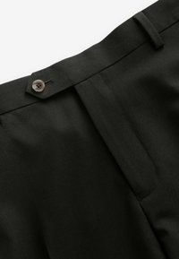 Pantalons noirs sur mesure présentant une texture lisse, une fermeture à bouton unique à la taille et un design de plis avant épuré.
