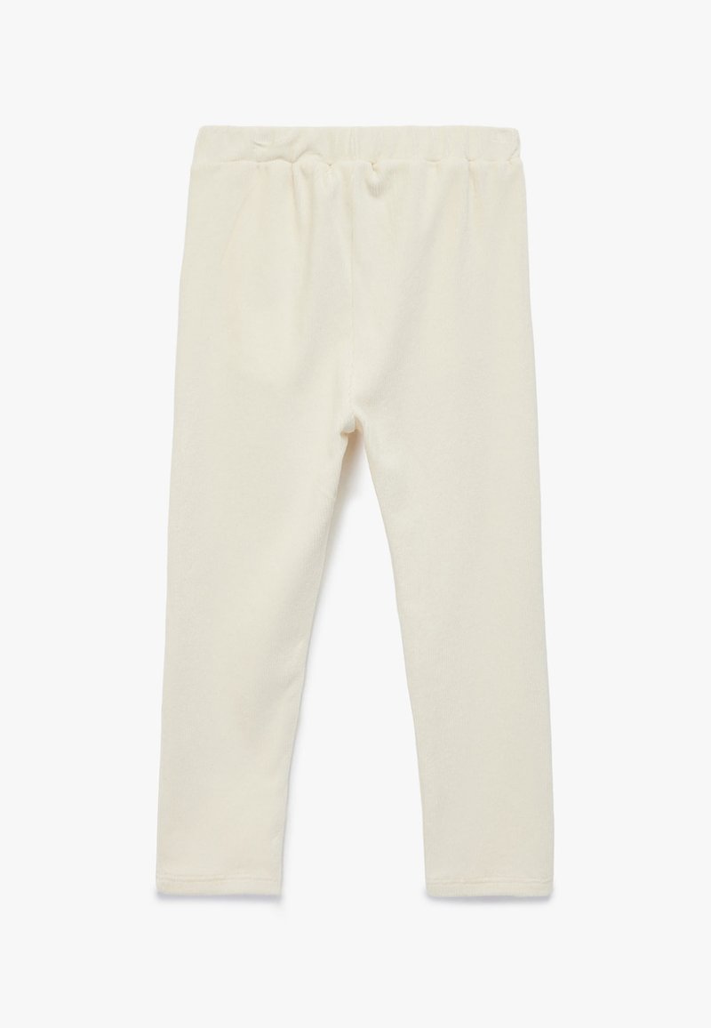 Ljust beige leggings med elastisk midja, tillverkade av mjukt tyg. Har en slät yta och en figurnära design.