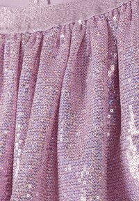 Tissu rose, embellie de sequins, avec un motif texturé et ondulé. Le matériau semble doux, avec des accents scintillants reflétant la lumière.