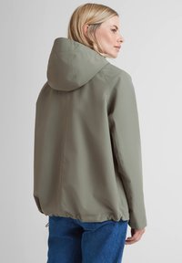 Long, lightweight green jacket with a hood, cinched hem, and smooth fabric texture. Features a minimalist design and no visible hardware.