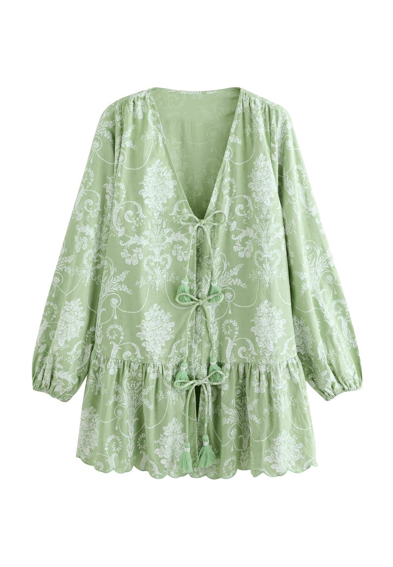 Vaaleanvihreä paita, jossa on kuvioitu design, syvä V-aukko, sidontadetaili edessä ja puffihihat, joissa on aaltoilevat alaosat.