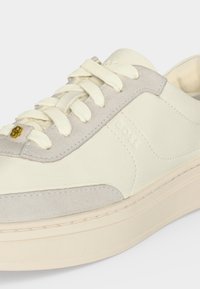 Κρεμ και ανοιχτό γκρι sneaker χαμηλού προφίλ με παχύ πάτο, υφασμάτινες κορδόνια, λεπτομέρειες από σουέτ και ανάγλυφο λογότυπο "BOSS" στο πλάι.