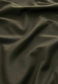 Tkanină texturată de culoare verde măslin închis, cu pliuri moi și un luciu subtil, având o suprafață netedă și ușor elastică.