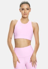 Világos rózsaszín sport crop top és illeszkedő magas derekú leggings, sima, rugalmas anyagból készült, letisztult kialakítással.