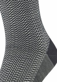 Calzini con motivo in bianco e nero caratterizzati da un design geometrico a spina di pesce, texture a coste, tallone rinforzato e punta rinforzata.