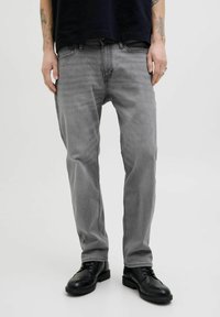 Grå denimjeans med rak passform, med femficksdesign och en jämn textur. Kombinerat med svarta läderskor.